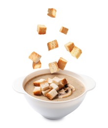 Image of Croutons falling into bowl of soup against white background