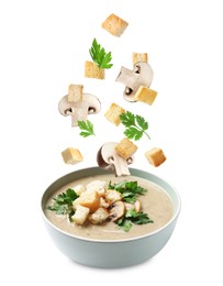 Image of Croutons and mushrooms falling into bowl of soup against white background