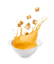 Image of Croutons falling into bowl of soup against white background