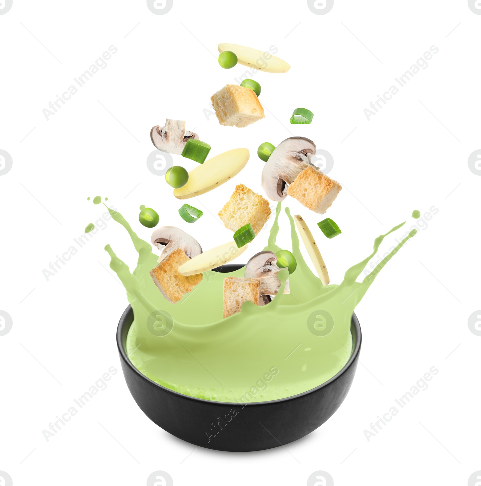Croutons, mushrooms, potato slices and green peas falling into bowl of soup against white background Image of Croutons, mushrooms, potato slices and green peas falling into bowl of soup against white background