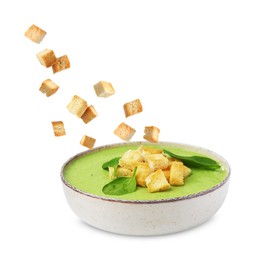 Image of Croutons falling into bowl of soup against white background