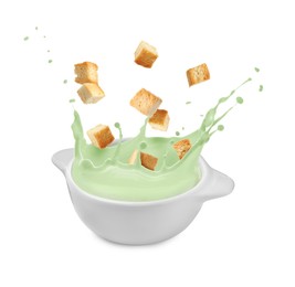 Image of Croutons falling into bowl of soup against white background