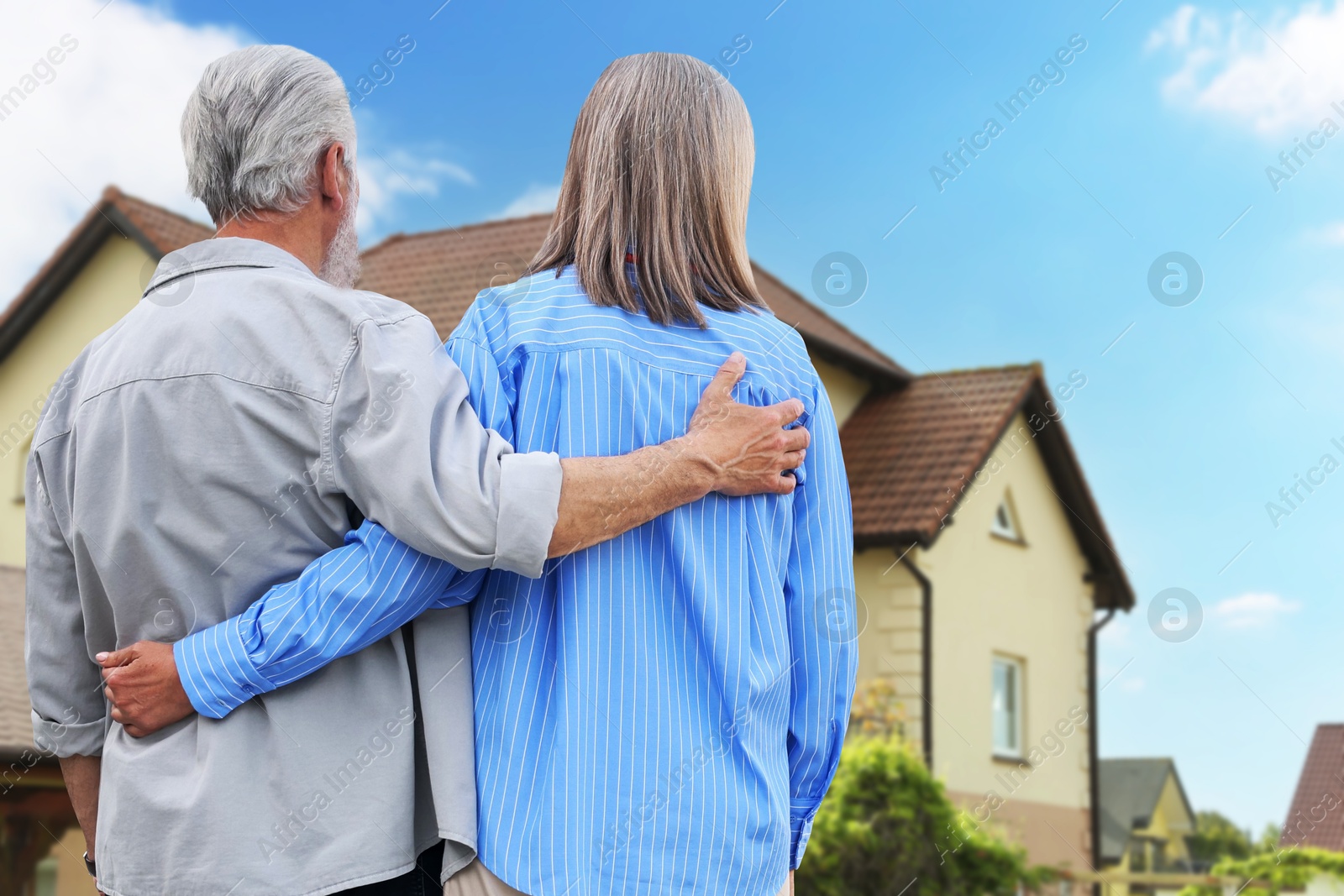 Senior couple looking at their house outdoors, back view Image of Senior couple looking at their house outdoors, back view