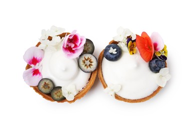 Photo of Delicious dessert. Tartlets with cream, berries and flowers isolated on white, top view