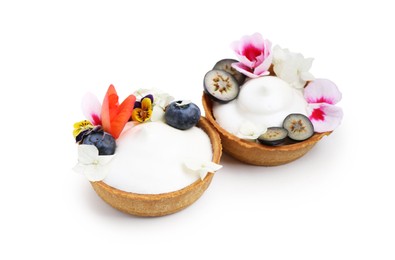 Photo of Delicious dessert. Tartlets with cream, berries and flowers isolated on white