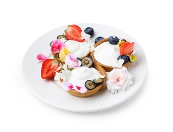 Photo of Delicious dessert. Tartlets with cream, berries and flowers isolated on white