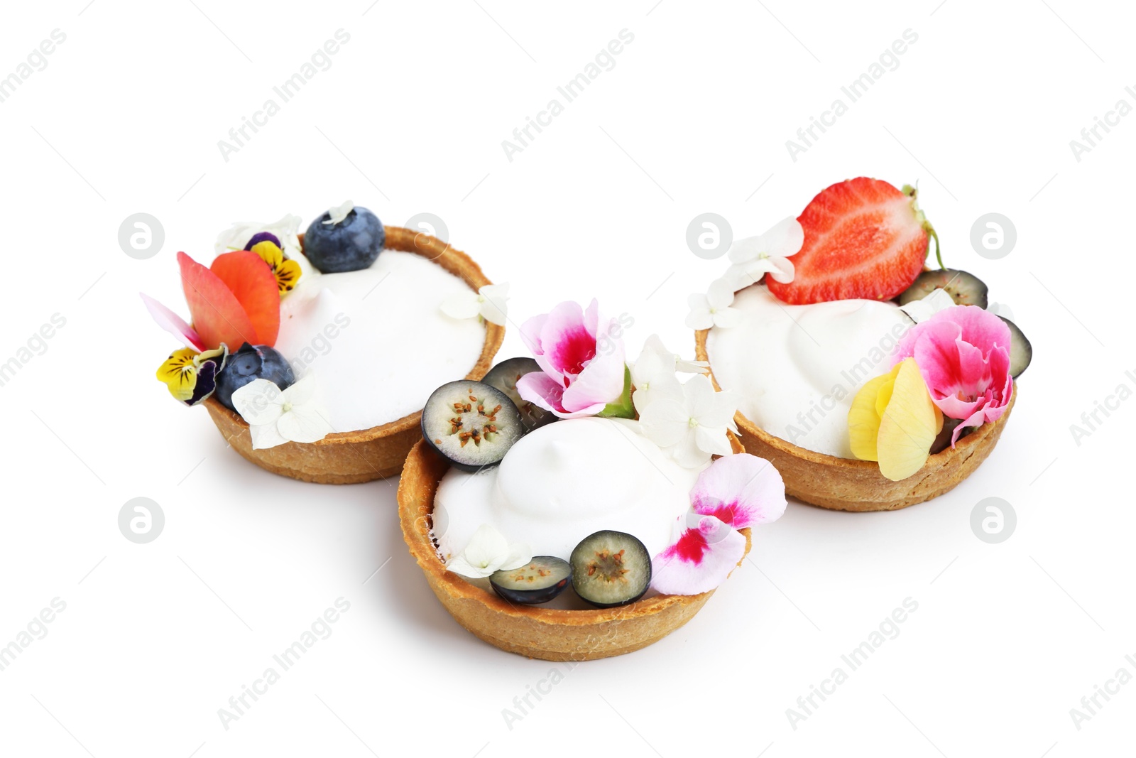Delicious dessert. Tartlets with cream, berries and flowers isolated on white Photo of Delicious dessert. Tartlets with cream, berries and flowers isolated on white