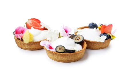 Photo of Delicious dessert. Tartlets with cream, berries and flowers isolated on white