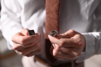 Photo of Man with cufflinks getting ready indoors, closeup