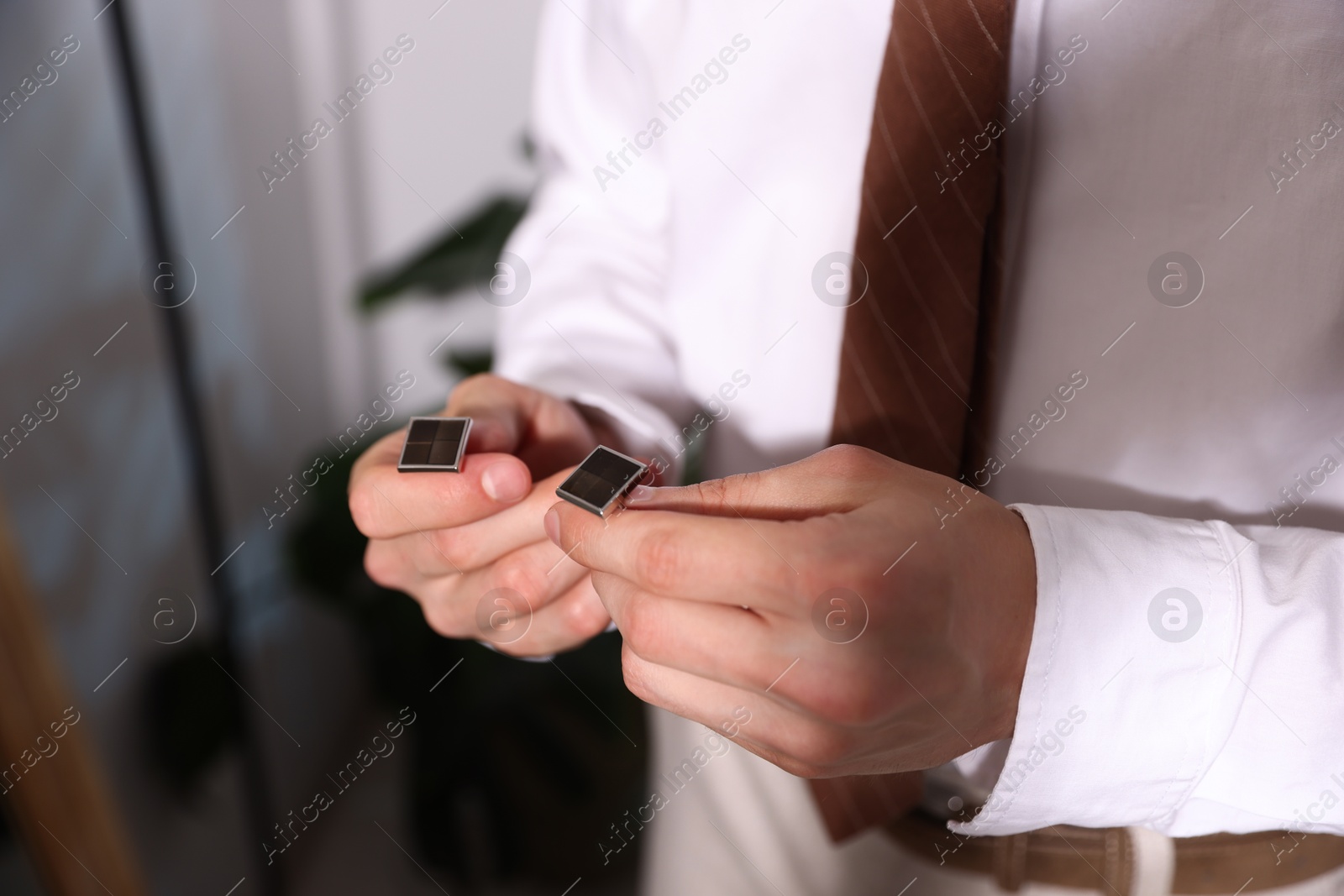 Man with cufflinks getting ready indoors, closeup Photo of Man with cufflinks getting ready indoors, closeup