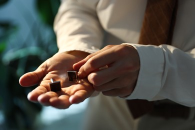 Photo of Man with cufflinks getting ready indoors, closeup