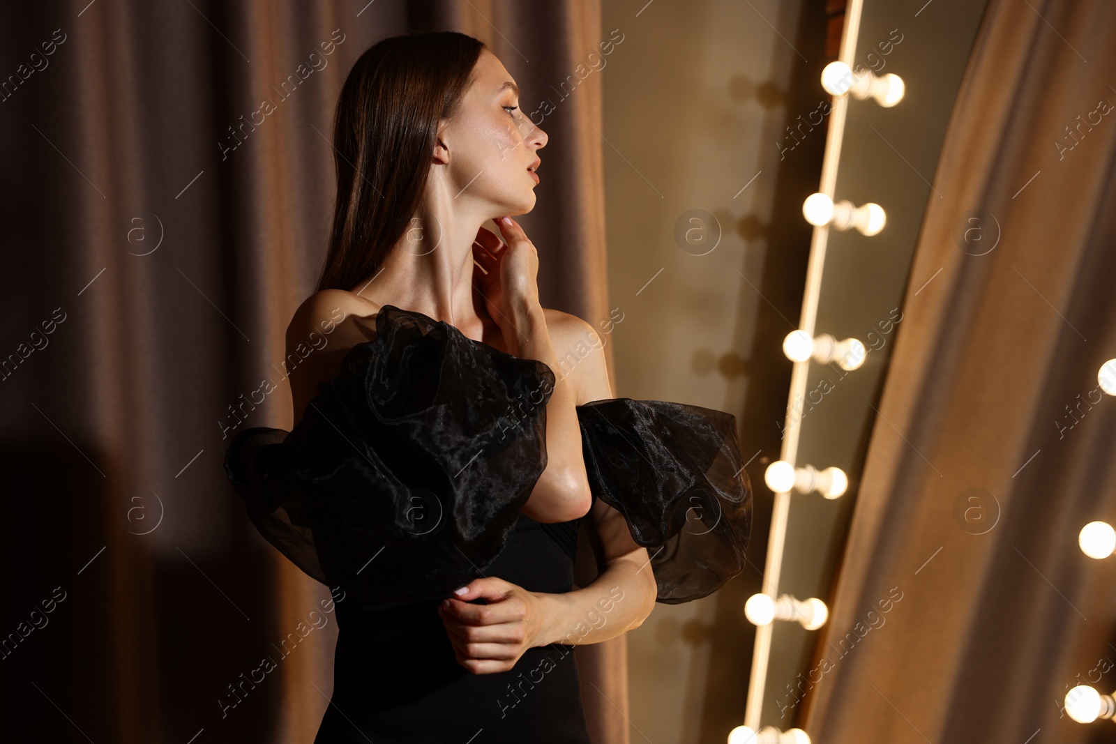 Beautiful woman getting ready near mirror indoors Photo of Beautiful woman getting ready near mirror indoors