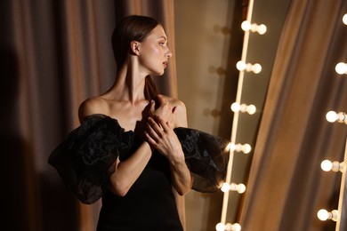 Photo of Beautiful woman getting ready near mirror indoors