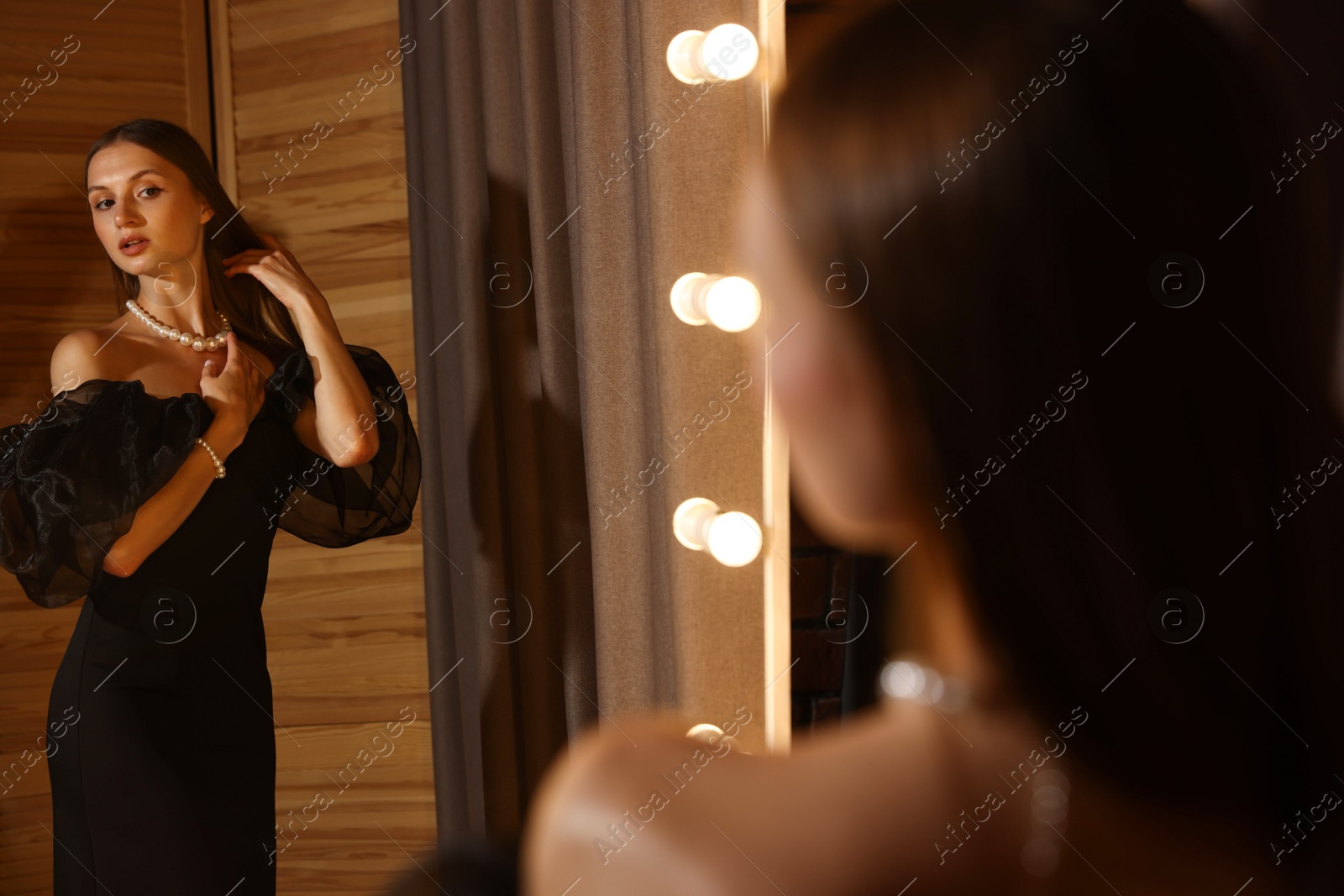 Beautiful woman getting ready near mirror indoors Photo of Beautiful woman getting ready near mirror indoors