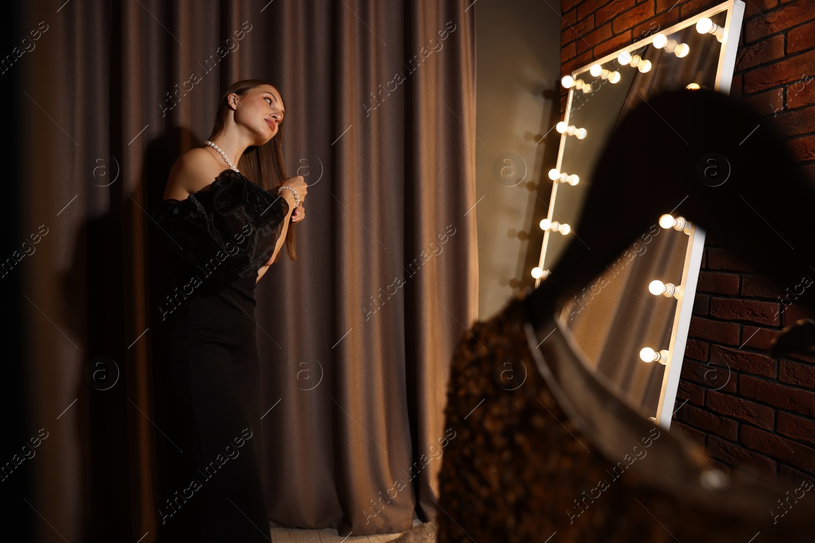 Woman brushing her hair while getting ready near mirror indoors Photo of Woman brushing her hair while getting ready near mirror indoors