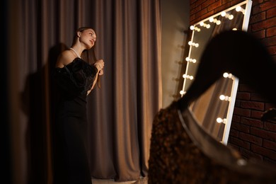 Photo of Woman brushing her hair while getting ready near mirror indoors