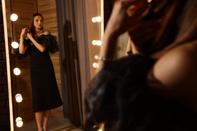 Photo of Woman brushing her hair while getting ready near mirror indoors
