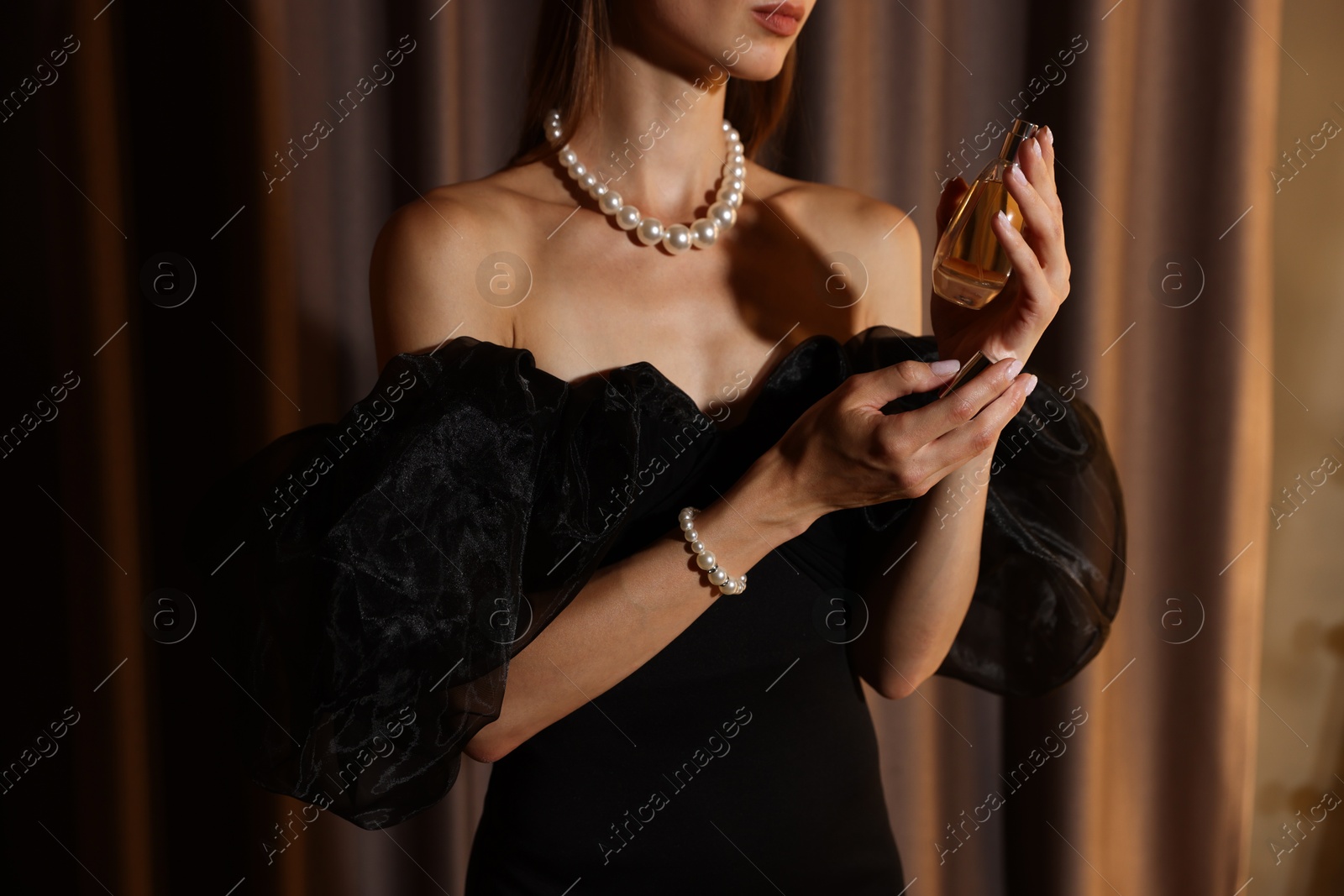 Woman with perfume getting ready indoors, closeup Photo of Woman with perfume getting ready indoors, closeup