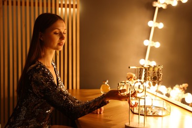 Photo of Beautiful woman getting ready at dressing table indoors