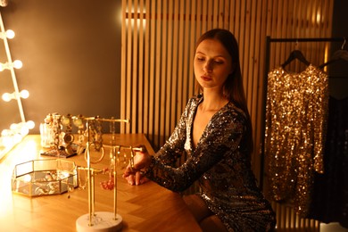 Photo of Beautiful woman getting ready at dressing table indoors