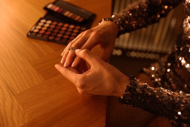 Photo of Beautiful woman getting ready at dressing table indoors, closeup