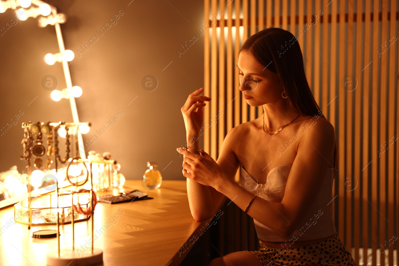 Woman wearing beautiful bracelet while getting ready at dressing table indoors Photo of Woman wearing beautiful bracelet while getting ready at dressing table indoors