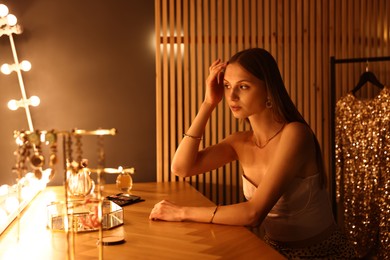 Photo of Beautiful woman getting ready at dressing table indoors