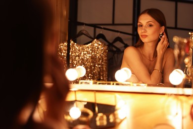 Photo of Beautiful woman getting ready at dressing table indoors