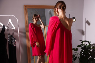 Photo of Beautiful woman getting ready near mirror indoors