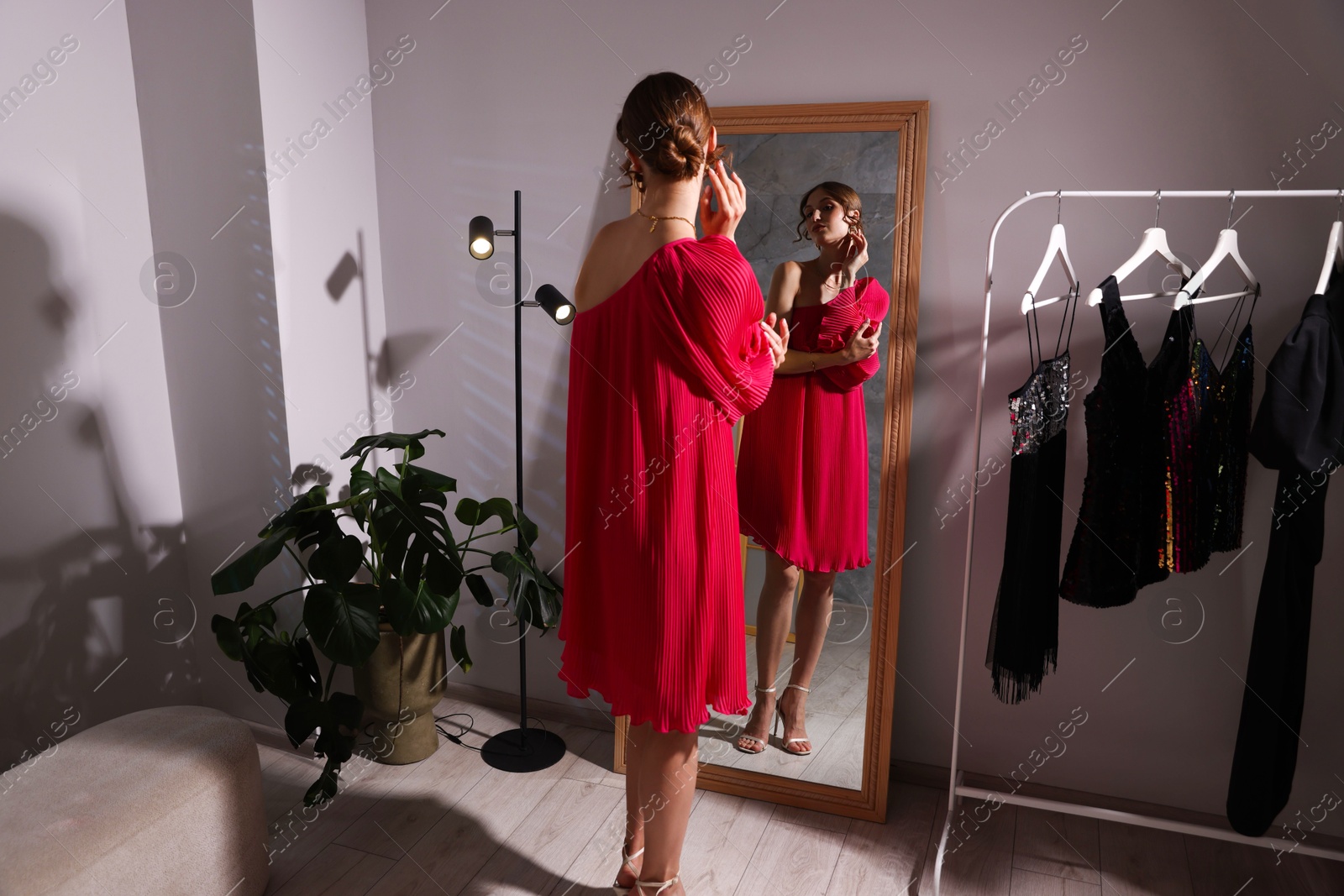 Beautiful woman getting ready near mirror indoors Photo of Beautiful woman getting ready near mirror indoors