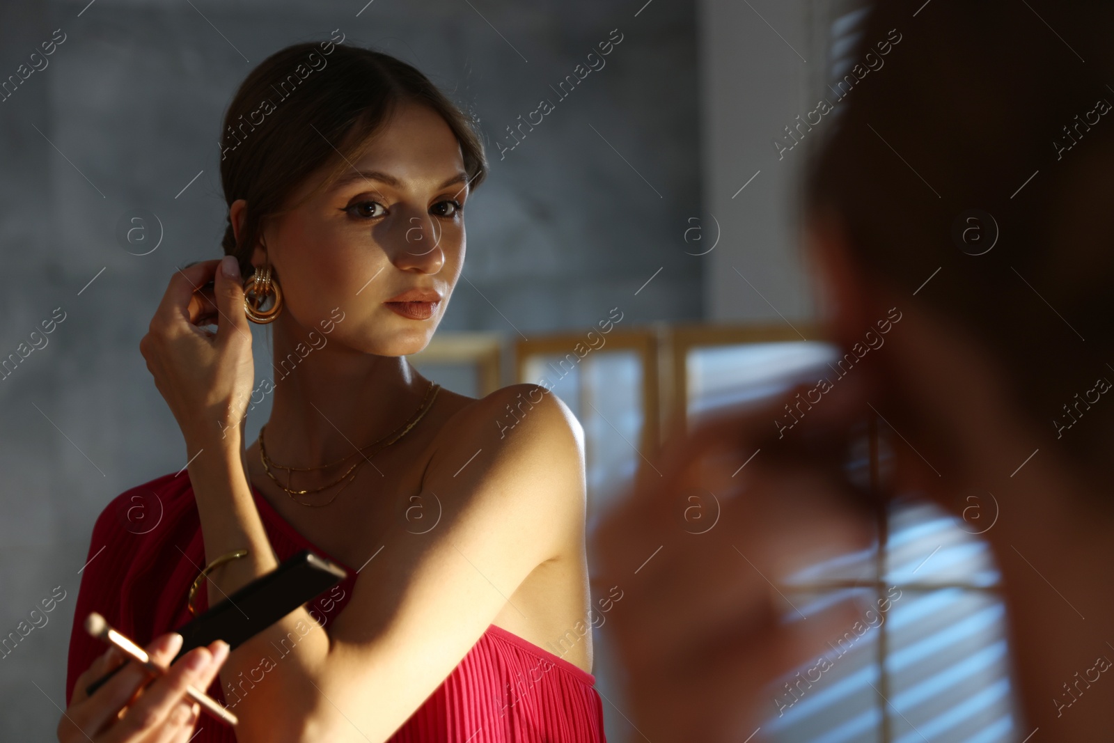 Beautiful woman with eyeshadow palette and brush getting ready near mirror indoors Photo of Beautiful woman with eyeshadow palette and brush getting ready near mirror indoors