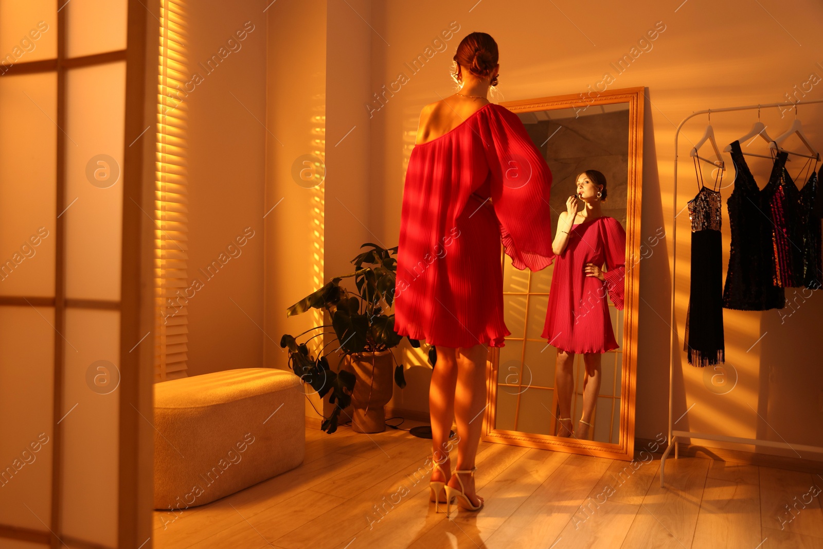 Beautiful woman applying lipstick while getting ready near mirror indoors Photo of Beautiful woman applying lipstick while getting ready near mirror indoors