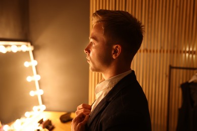 Photo of Man in stylish outfit getting ready indoors