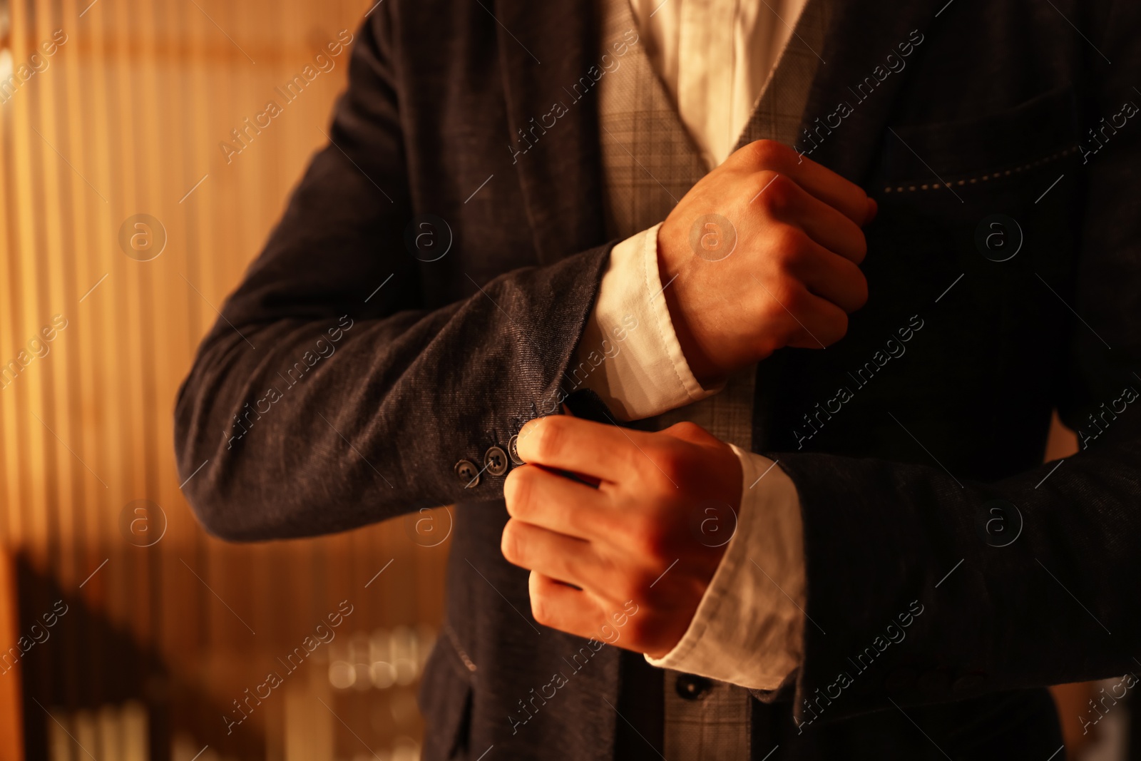 Photo of Man in stylish outfit getting ready indoors, closeup