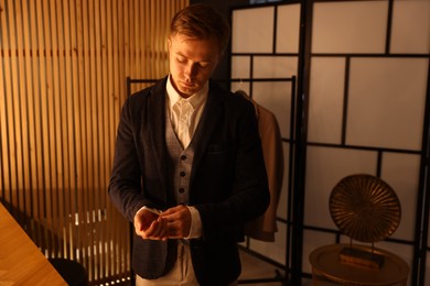 Photo of Man in stylish outfit getting ready indoors