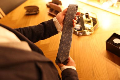 Photo of Man with necktie getting ready at dressing table indoors, above view