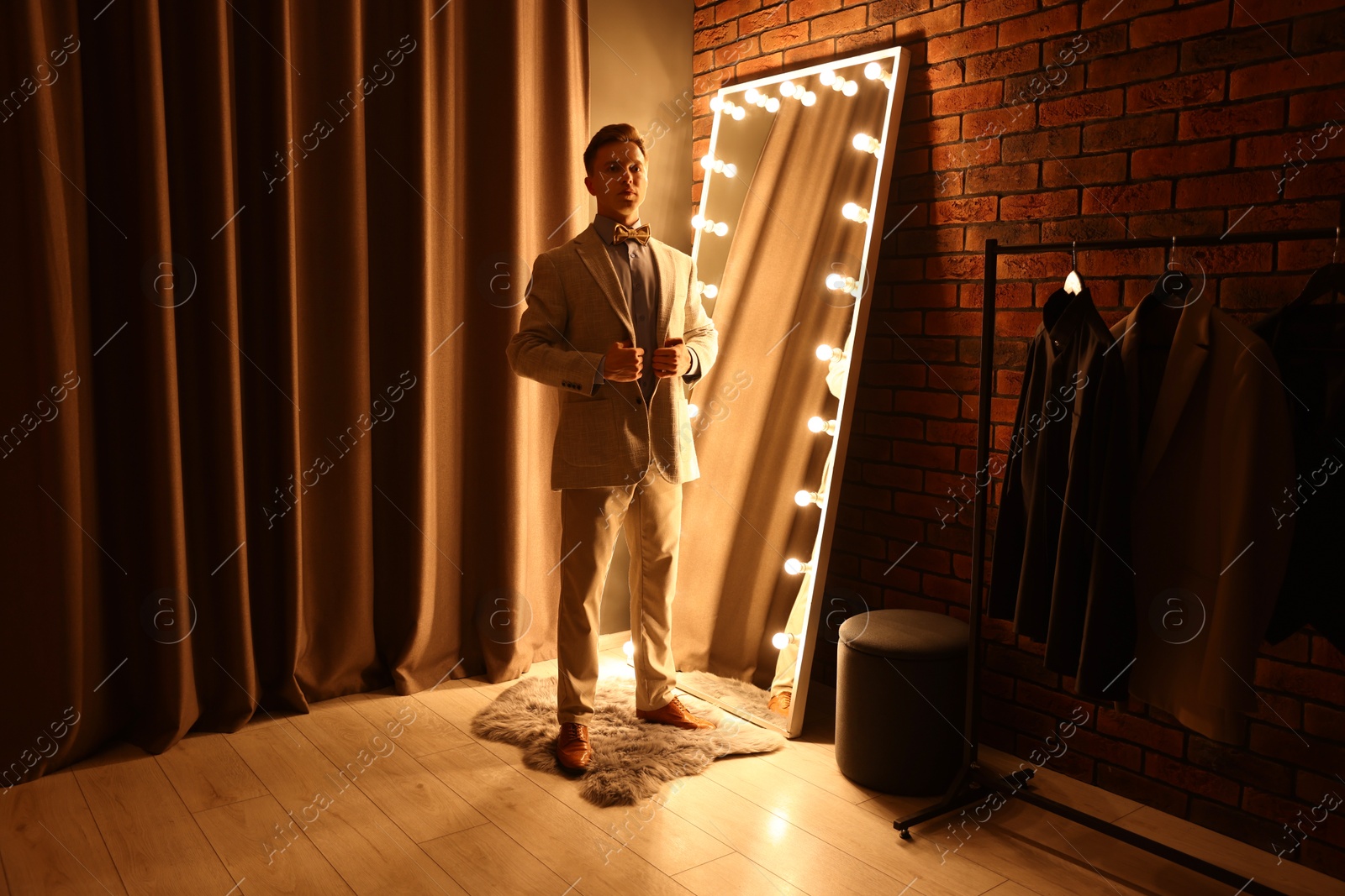 Handsome man getting ready near mirror indoors Photo of Handsome man getting ready near mirror indoors