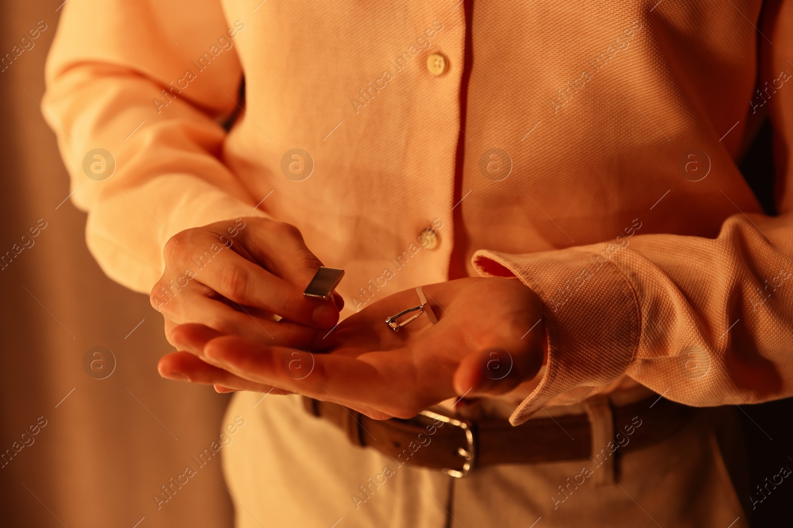 Photo of Man with cufflinks getting ready indoors, closeup