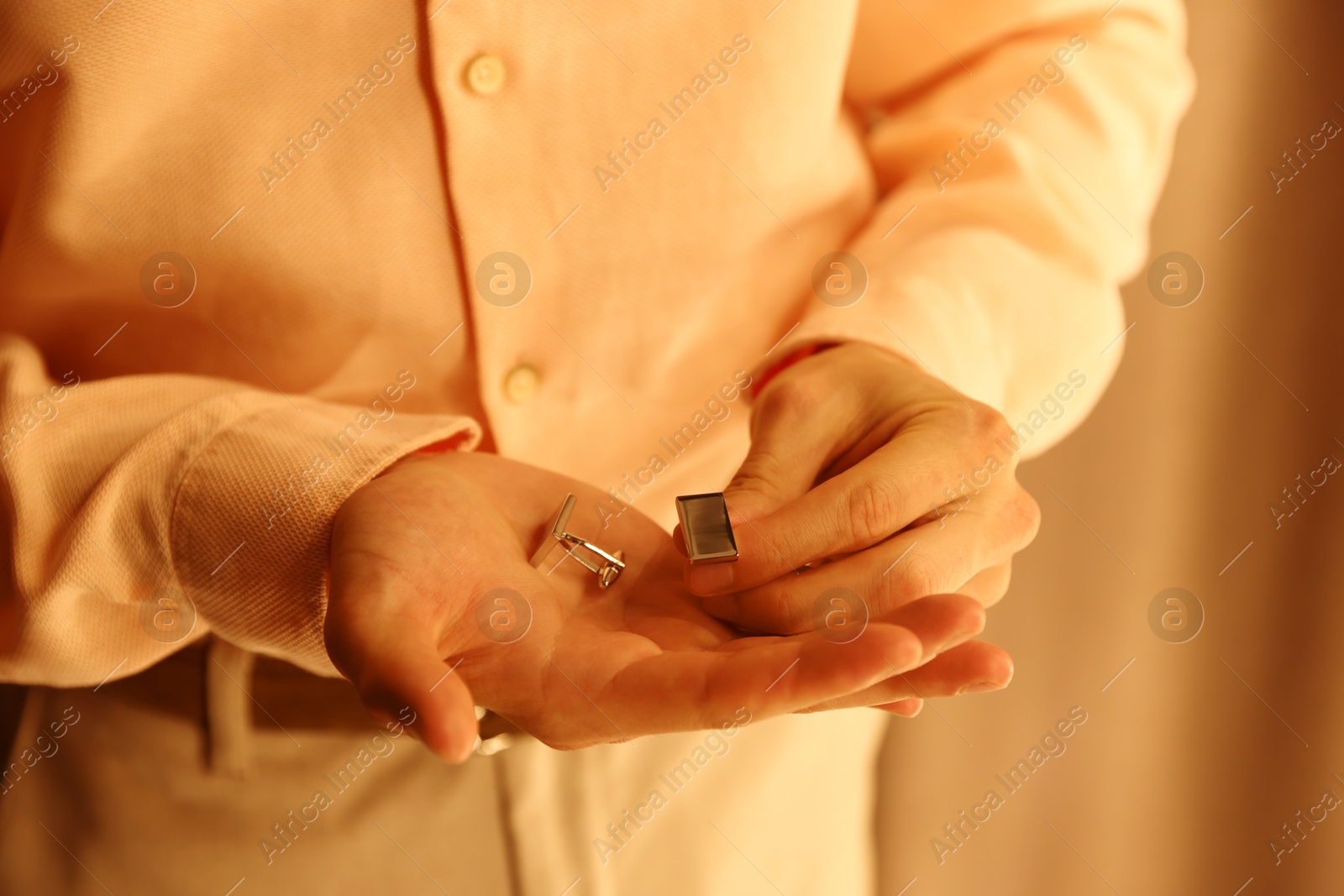 Photo of Man with cufflinks getting ready indoors, closeup