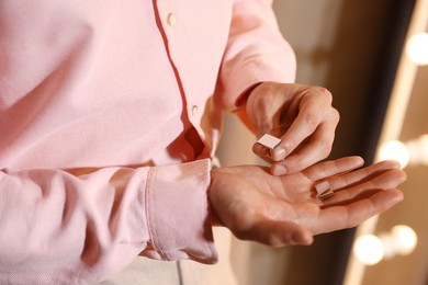 Photo of Man with cufflinks getting ready indoors, closeup