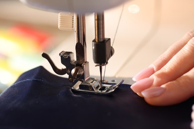 Photo of Woman working with sewing machine, macro view