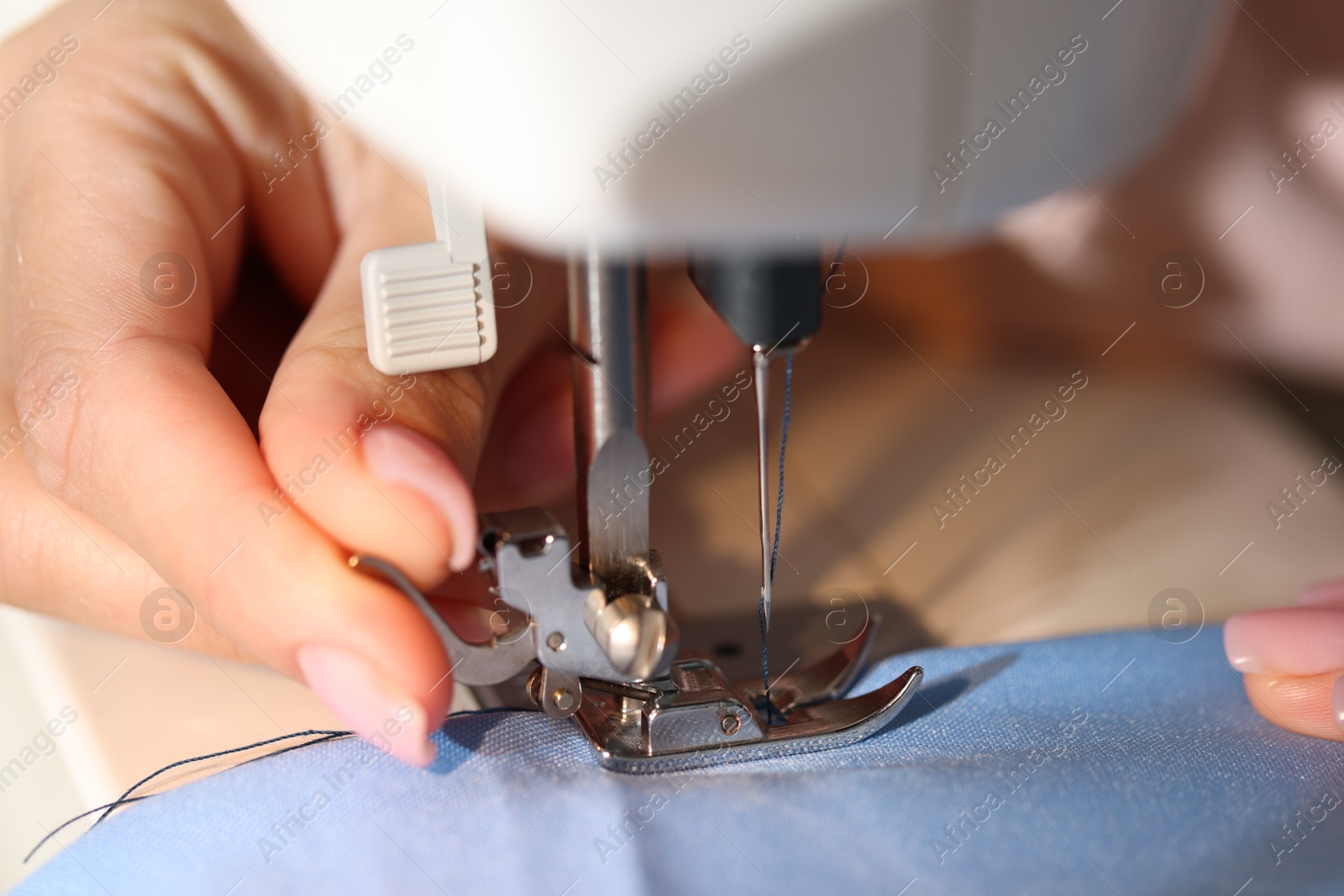 Photo of Woman working with sewing machine, macro view