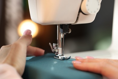 Photo of Woman working with sewing machine on blurred background, macro view