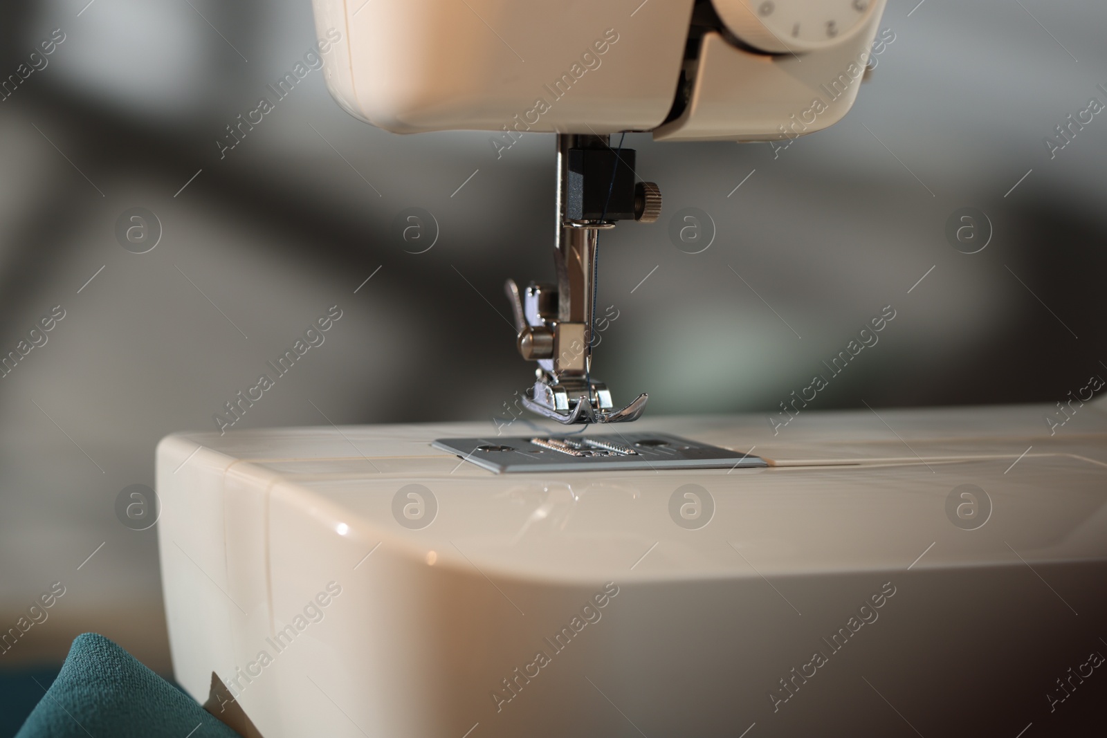 Sewing machine with thread on blurred grey background, macro view Photo of Sewing machine with thread on blurred grey background, macro view