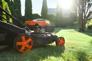 Photo of One lawn mower on green grass in garden, closeup. Space for text