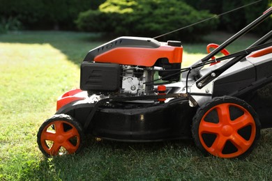 Photo of One lawn mower on green grass in garden, closeup