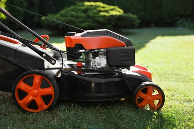 Photo of One lawn mower on green grass in garden, closeup