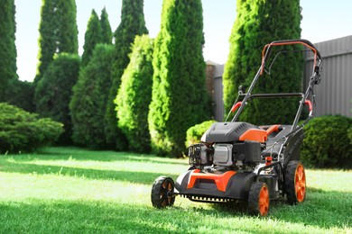 Photo of One lawn mower on green grass in garden, space for text