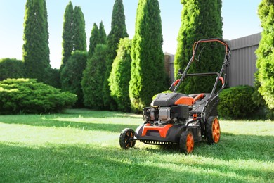 Photo of One lawn mower on green grass in garden, space for text