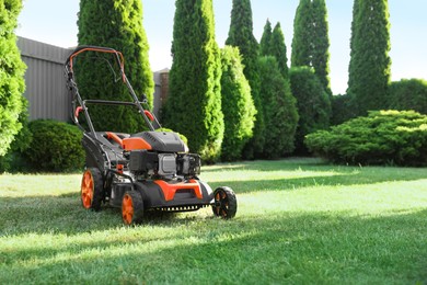 Photo of One lawn mower on green grass in garden, space for text